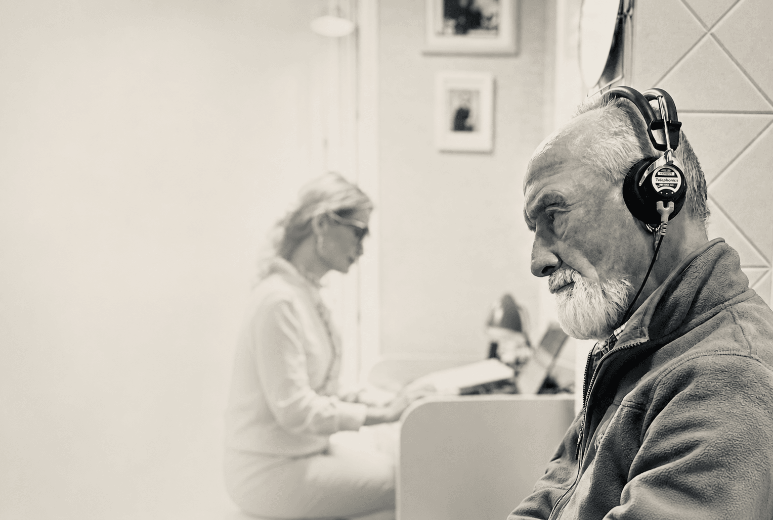 An elderly man wearing audiometry headphones during a hearing test